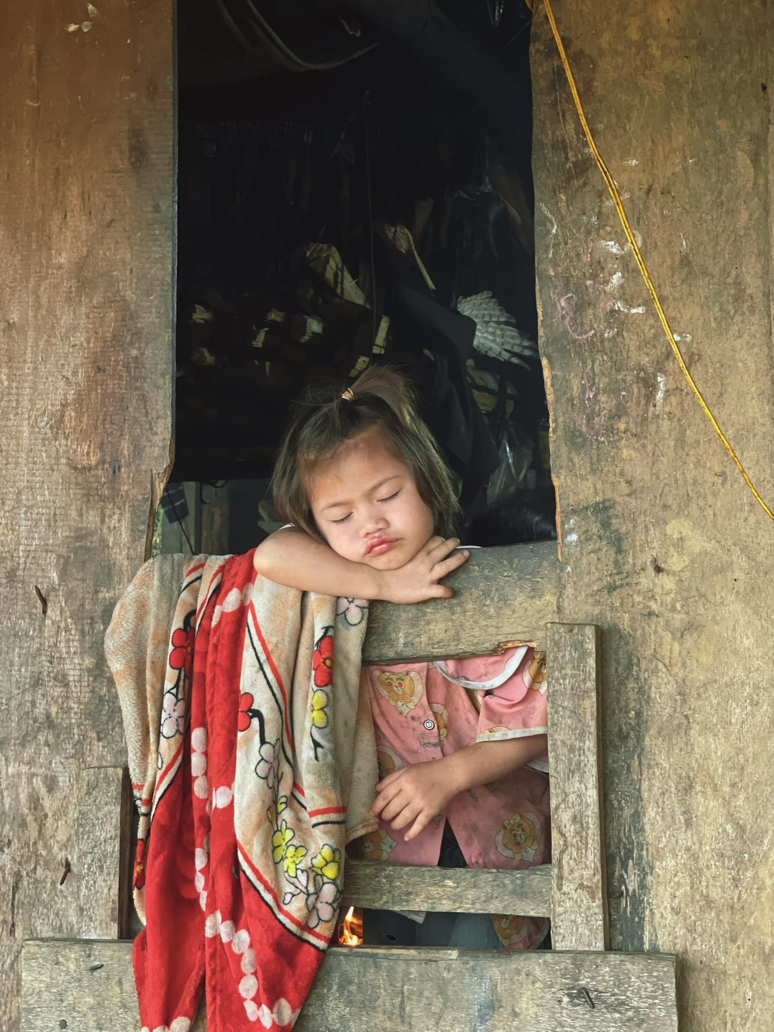 Bé gái Ca Dong ngủ gật bên cửa sổ nhà sàn